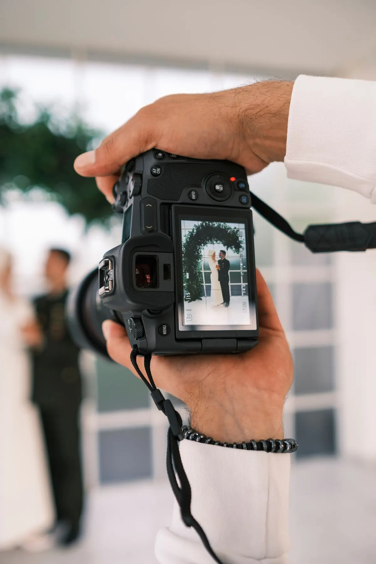 Fotógrafo capturando a una pareja de novios con su cámara en una boda
